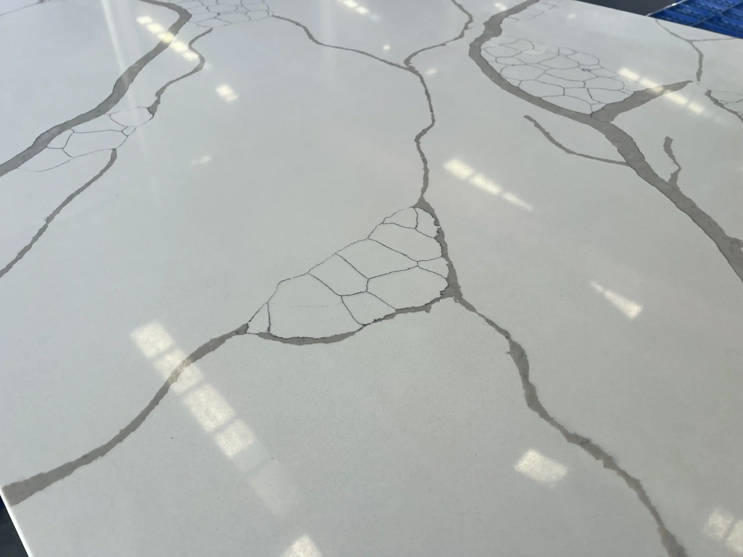 Close view of bold gray veining on a polished Calacatta quartz surface