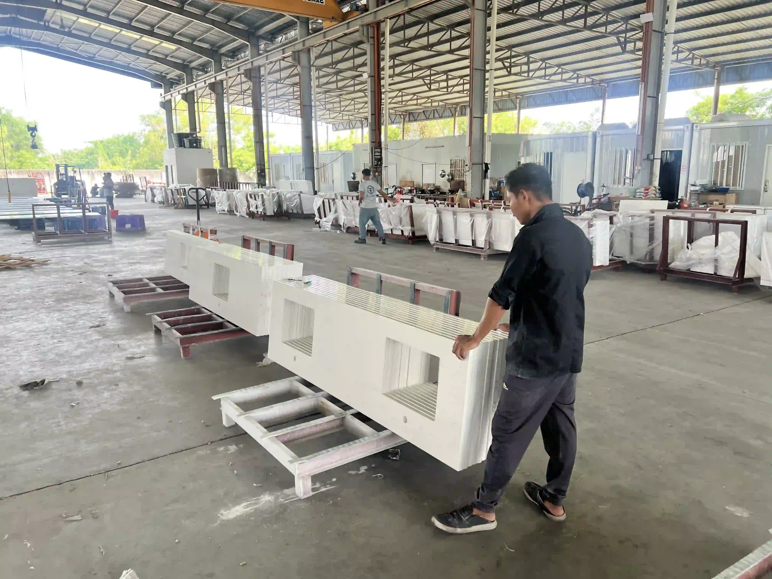 Factory worker inspecting a fabricated quartz countertop before project packing