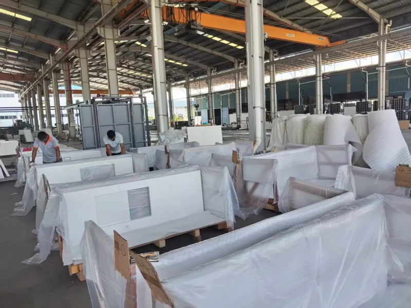 Workers applying protective packaging to quartz countertops at a Malaysia quartz factory
